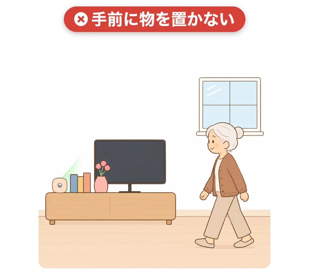 テレビ台の上のセンサーの手前に本と花瓶を置いた避けたい例。物がセンサーの前をふさいでいる
